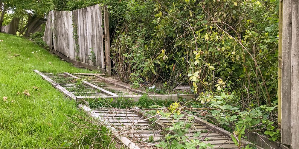 Check your retaining walls and fences for early signs of failure