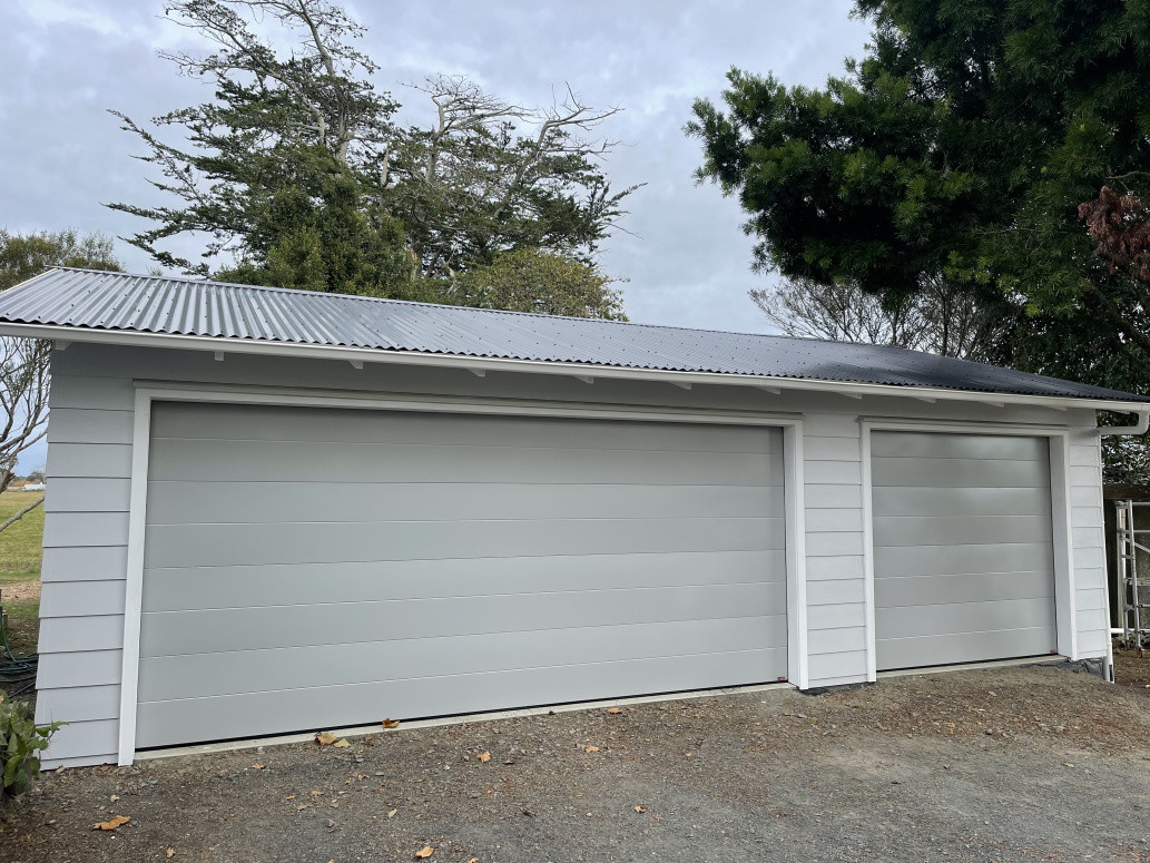 Fibre cement weatherboard to match existing home. Remote control garage doors with EV charging powerpoints