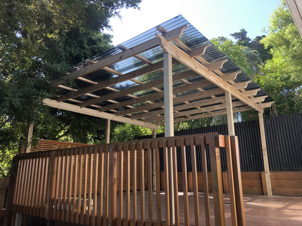 New pergola added to existing deck with tinted polycarbonate roof