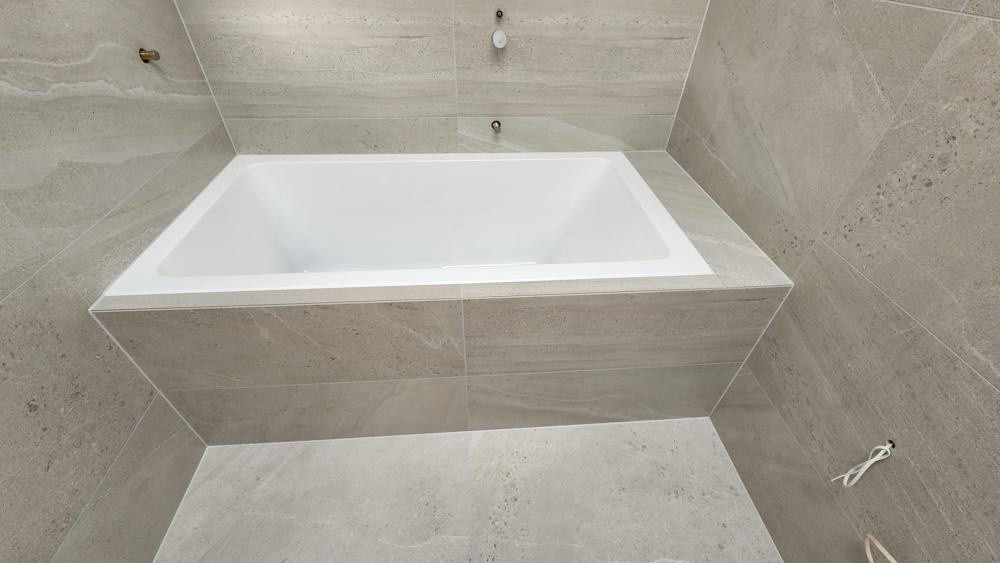 Tiling around  bathtub.