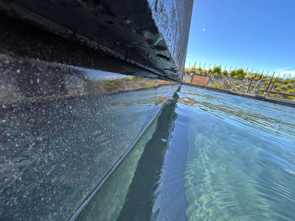 ½ Black concrete overhang, view from in pool