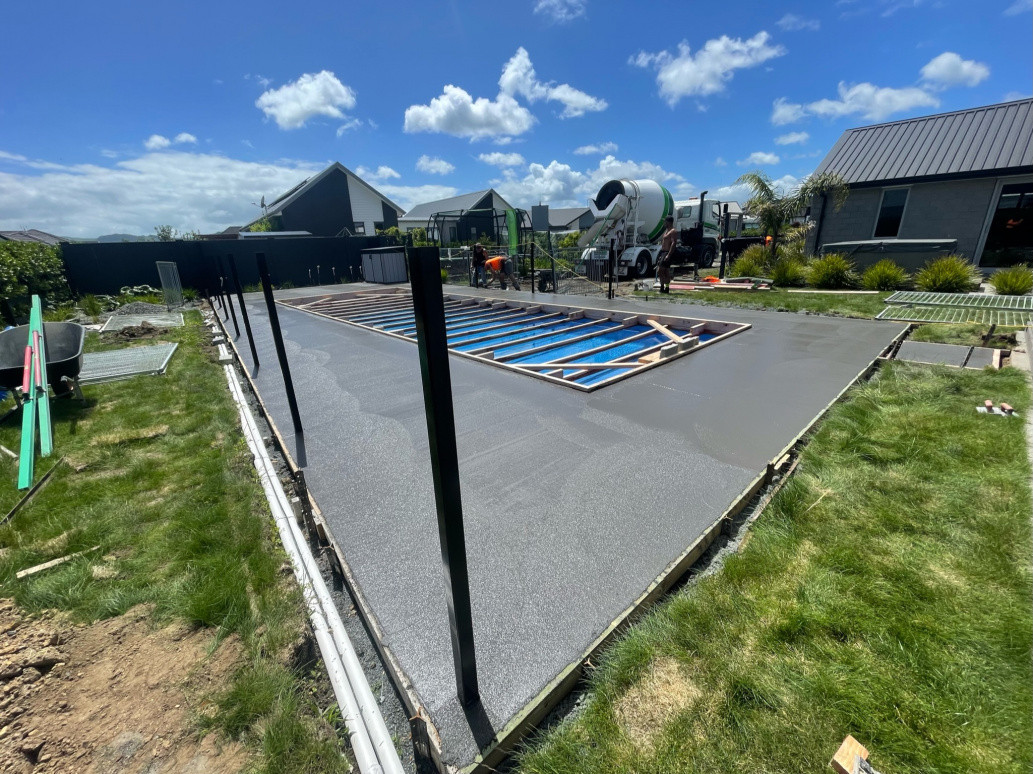 ¾ black concrete being laid