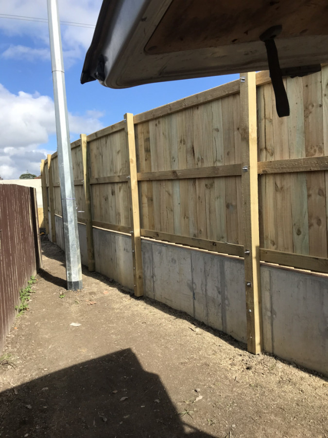 Timber fencing we built, bolted to a concrete retaining wall