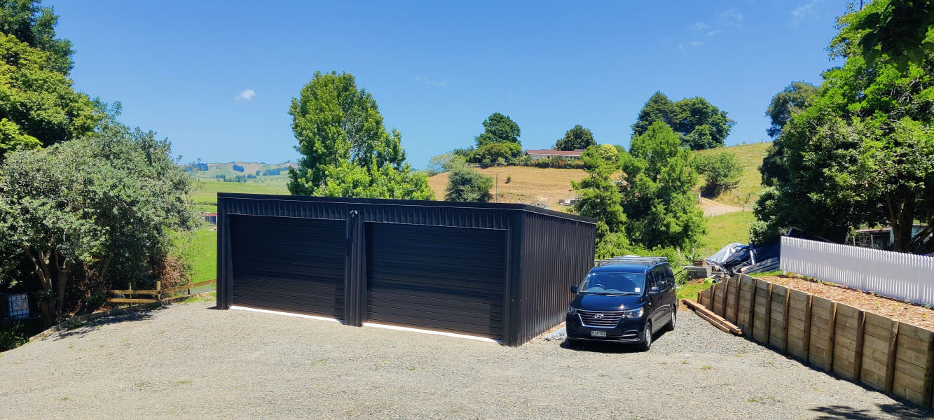 New 10x7 shed with automatic doors and concrete pad, new retaining wall and painted picket fence on top.