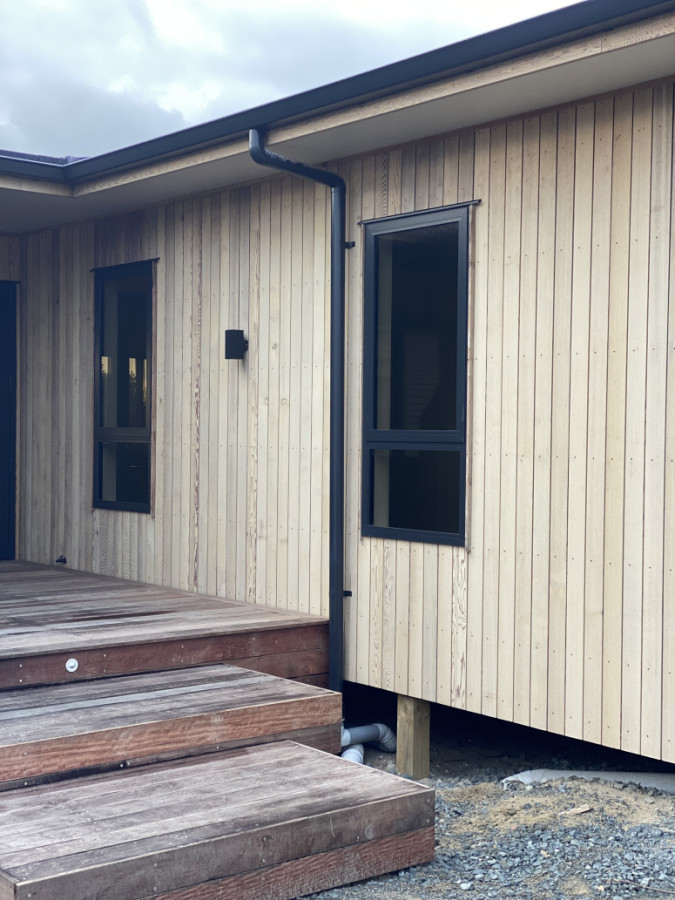 Another glimpse of our Omaha new build — vertical shiplap cedar cladding with dark Ironsand-tinted negative detail for a sharp, modern finish. Topped off with a statement Kwila deck.