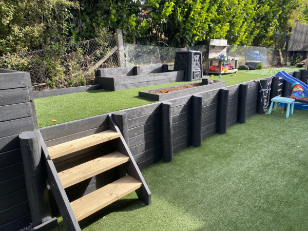 Artificial turf with Kids play area and vege garden box.