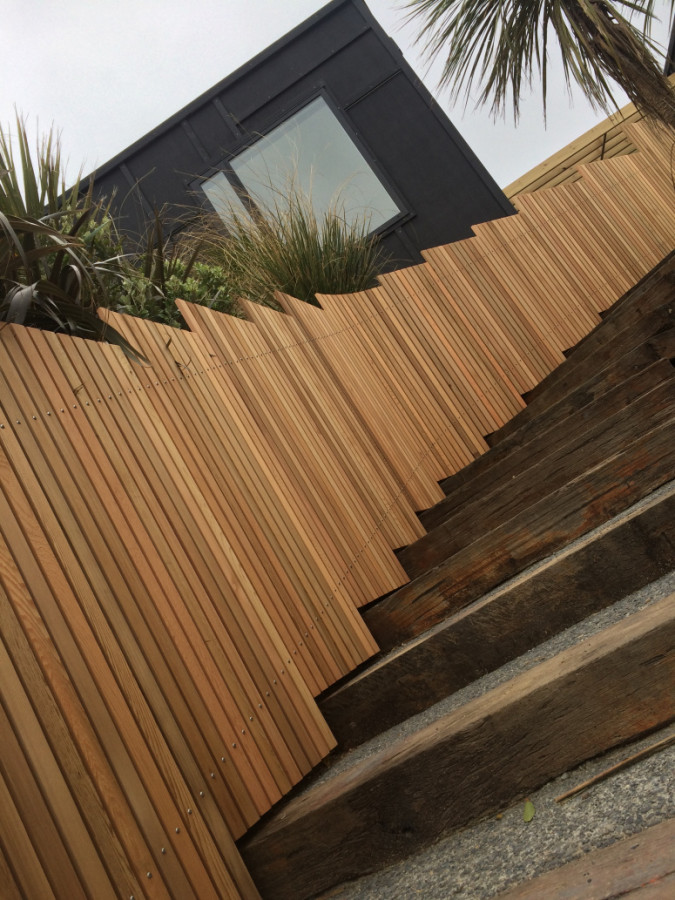 Exposed aggregate stairs in sleepers with a cedar fence.