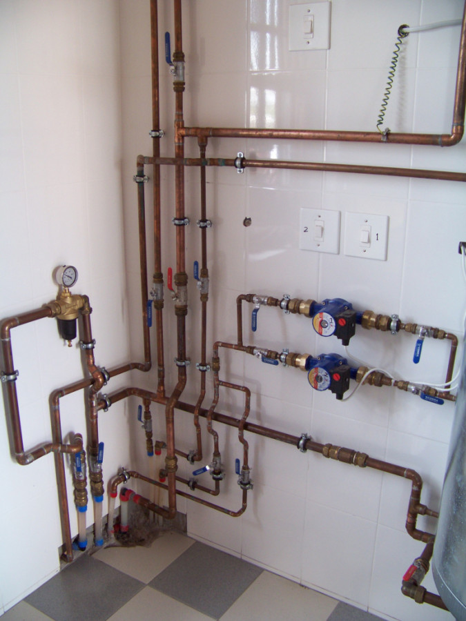 Exposed copper pipes for heating water and floor slabs.