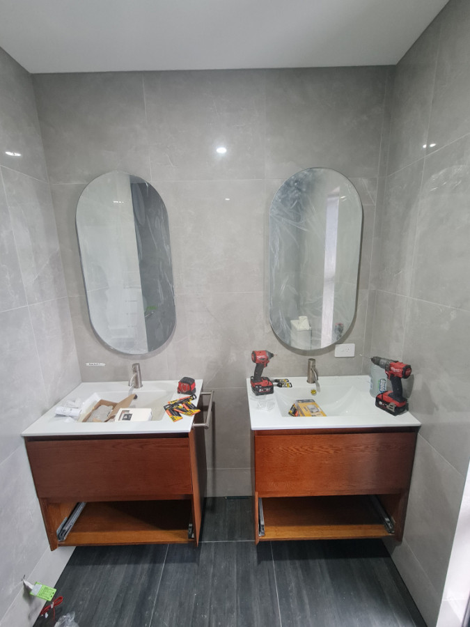 Two vanities and mirrors installed onto tiled walls