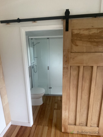 New shower and toilet in with a recycled sanded remu door