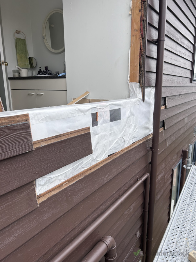 Building wrap and tape protecting new studs