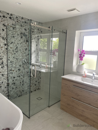 Frameless sliding corner shower