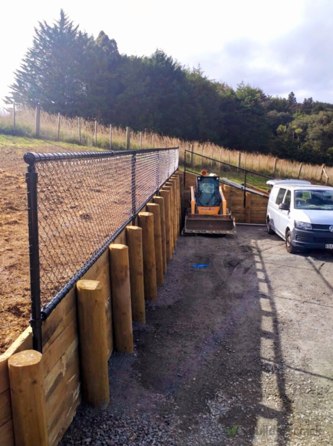 1.5 meter high retainer wall with a 1 meter high safety barrier fencing on top.