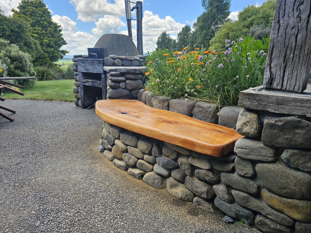 A couple of solid macrocarpa handcrafted seats to kick back on a custom-built BBQ and pizza oven setup ready for those long summer evenings. 🍕🌿 Built to last and made for living. What's your ideal backyard feature?