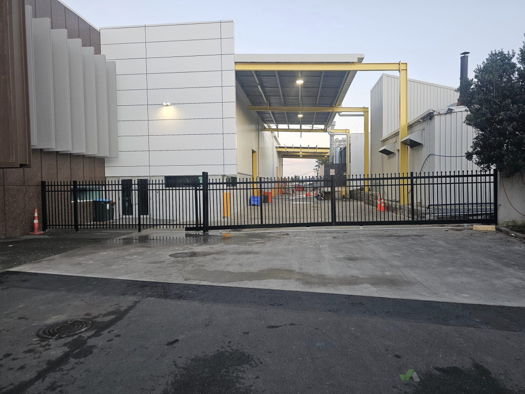 Bi-parting sliding gates with aluminum fencing and pedestrian gate