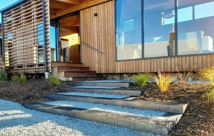 Tiered sleepers with corten steel faces to this architectural entryway