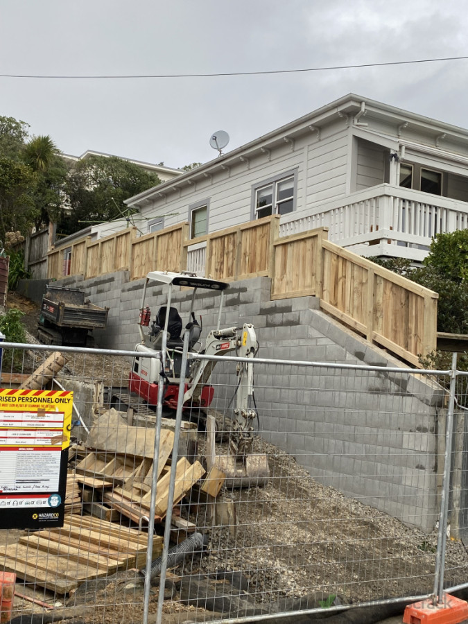 Block retaining wall with a fence