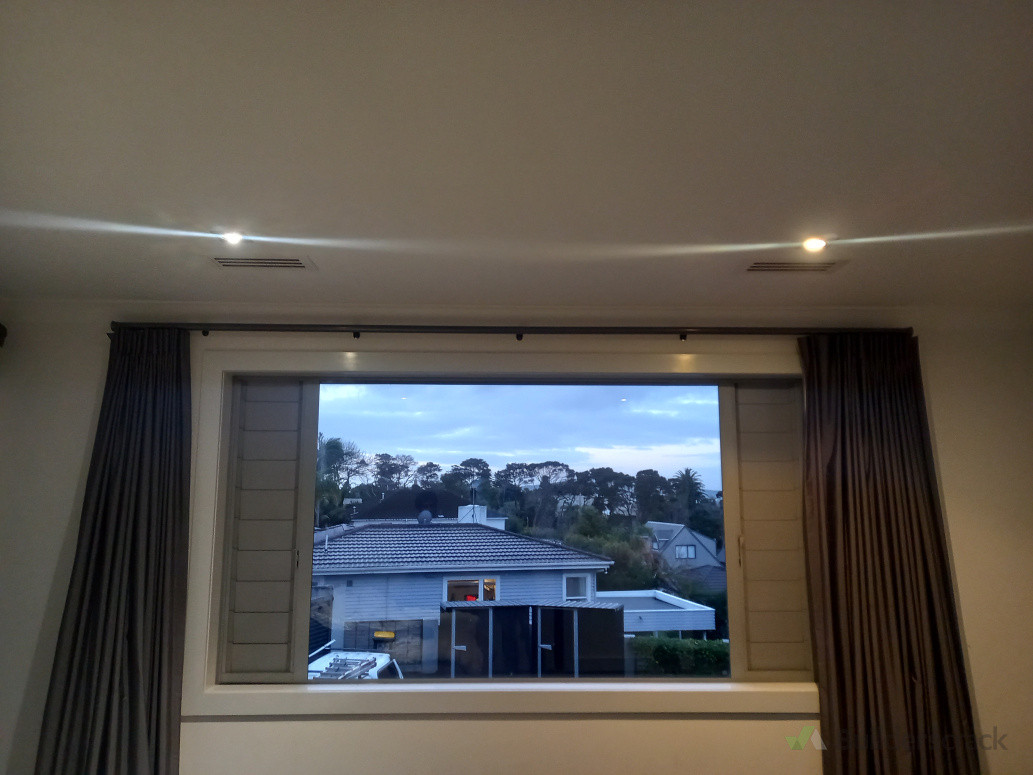 Two more supply grills in a bedroom, lined up with lights.