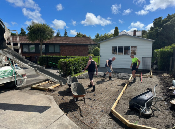 Concrete Pouring: Team members carefully pouring and leveling the concrete base, ensuring a solid foundation for the carport construction.