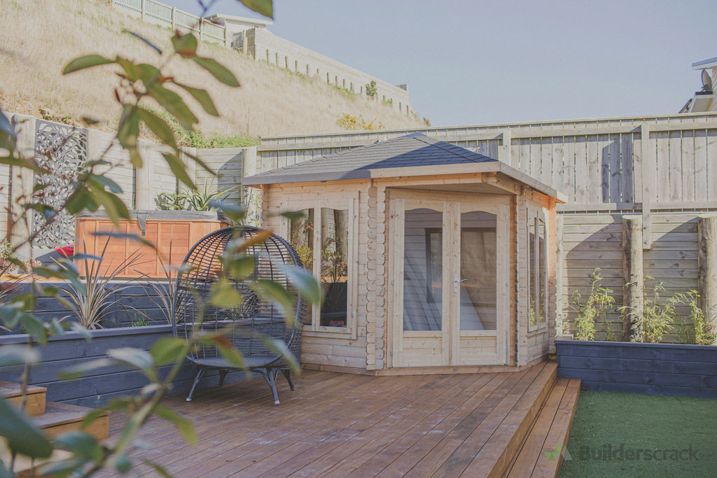 A kitset studio assembled over hardwood decking with easy access raised planters and artificial lawn