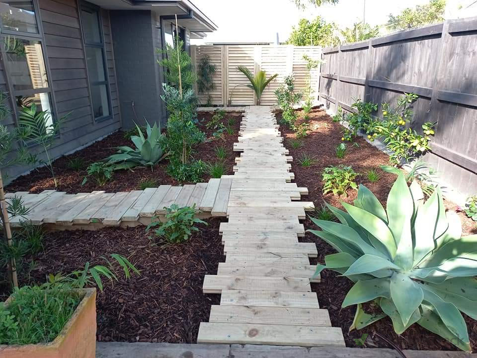 Jiggery raised walkway with tropical planting and bark mulch. No grass