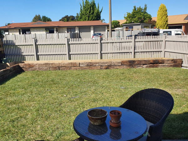 A picket fence with raised flower bed inside