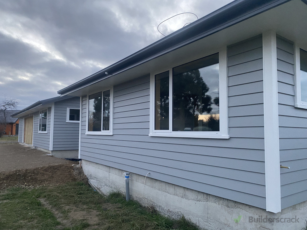 Weatherboard dark colour and windows and corners white