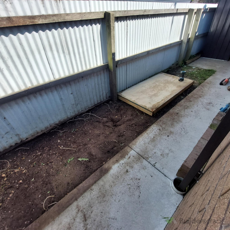 Weeds removed and excess soil taken away to level area. Shed based installed.