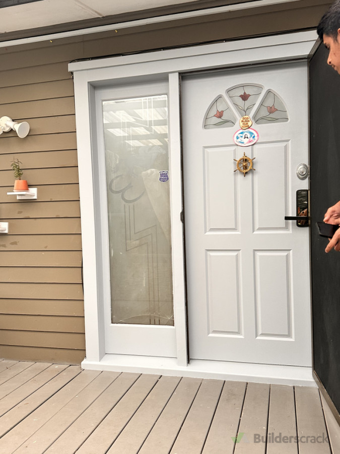 Charming Front Entryway - A beautifully designed white door with a glass panel and side window, set against a cozy exterior wall.