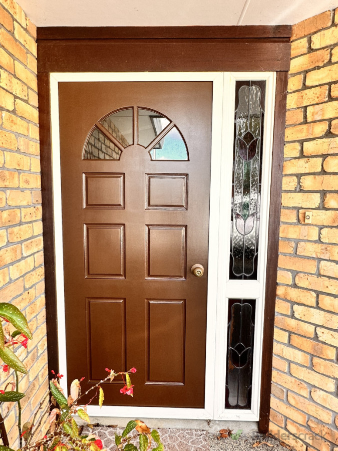 Welcoming Front Door - A classic wooden entrance door surrounded by a neat brick finish.