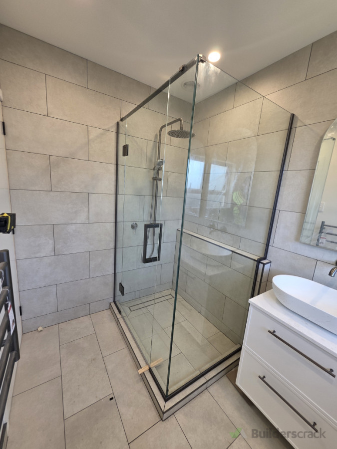 Custom frameless shower with nib cut out and gun metal hardware