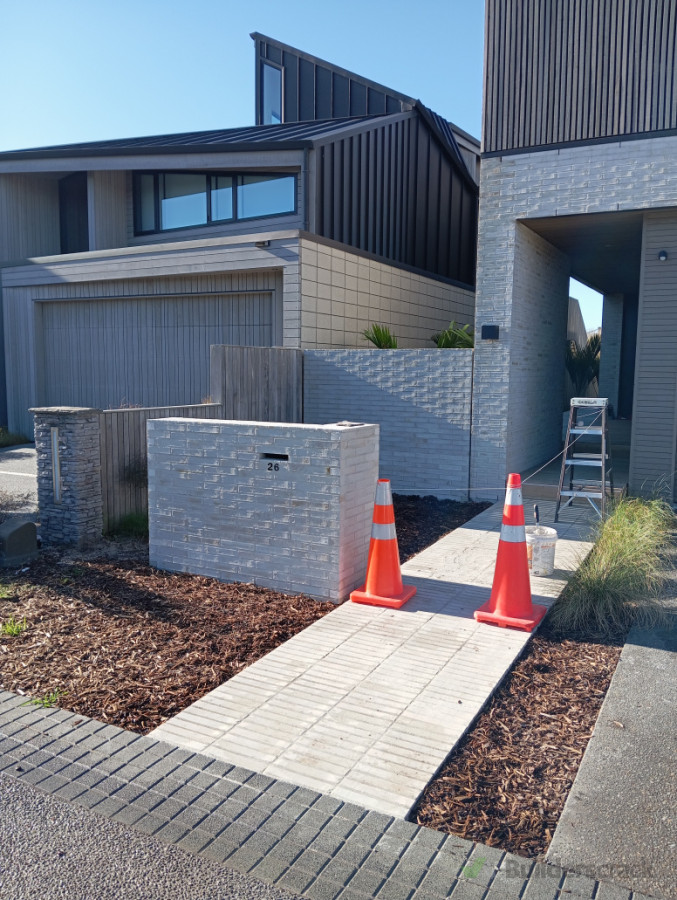 Residential brick house, letter box, footpath and landscape brickwall.