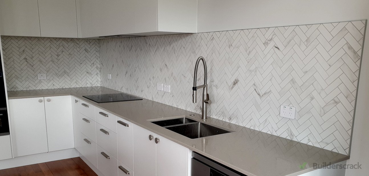 Classic marble herringbone mosaic tiles enhancing the kitchen splashback with timeless elegance, installed by Direct Tiling
