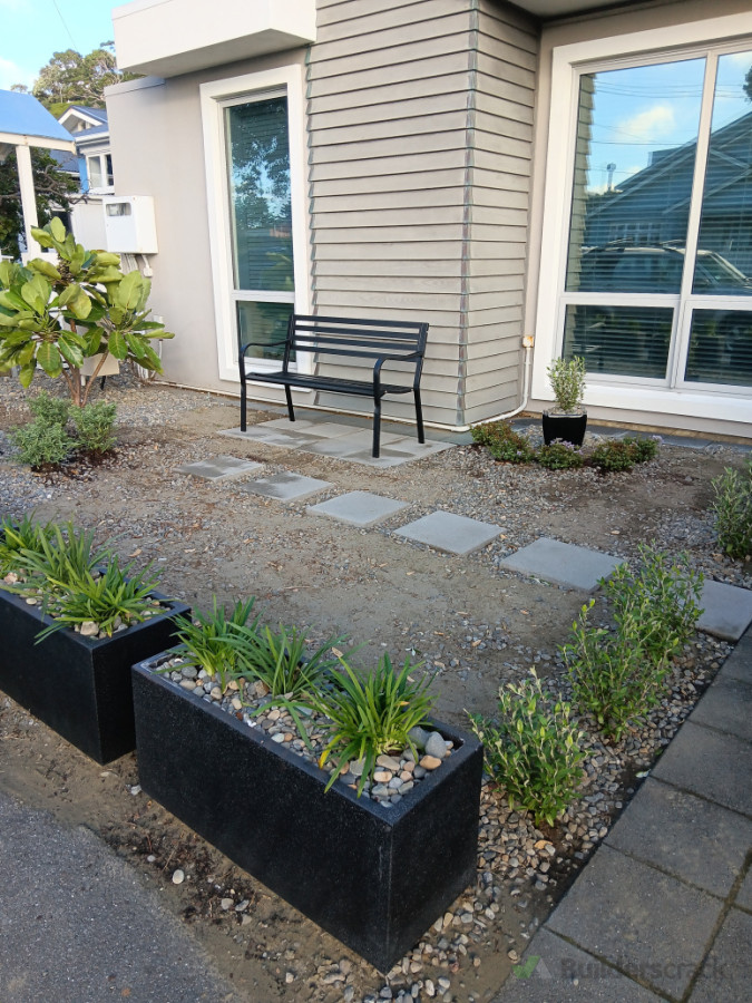 Pavers laid, planter boxes and plants installed.