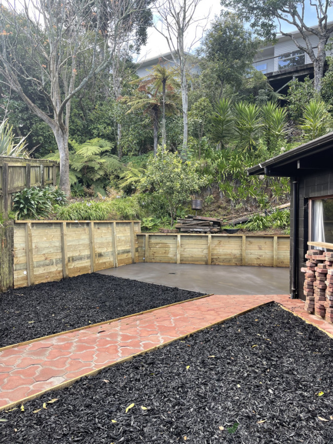 Paved path with black mulch for garden, with concrete pad and retains wall