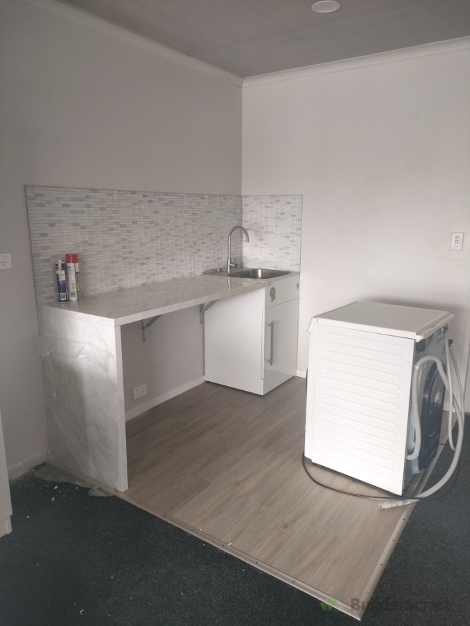 Laundry counter, tiles on wall and floor cover.