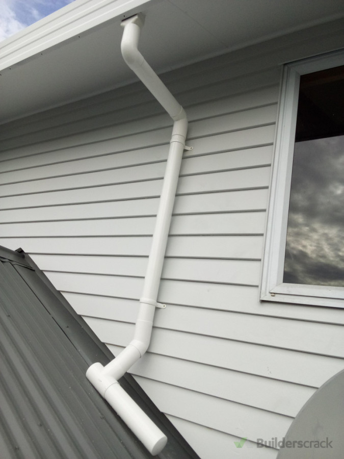 "Downpipe with spreader installed to ensure even water distribution and protect roofing surfaces."