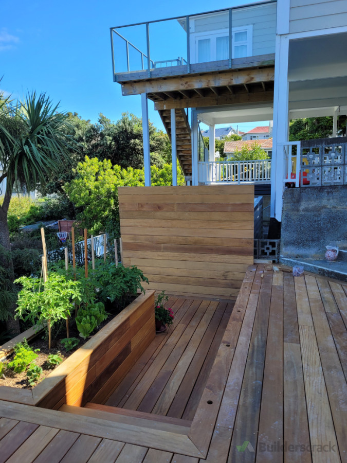 Large hardwood deck with planters and screen wall in hataitai