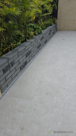 Paving, strip drain and retaining wall with tiling detail