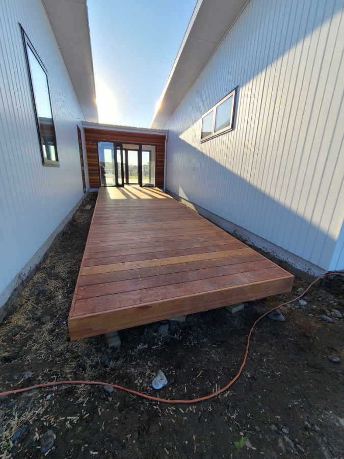 Kwila decking leading up to the front door, surrounded by redwood cedar.