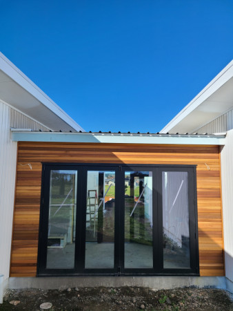 Red cedar rusticated weatherboard with clear coat of oil.