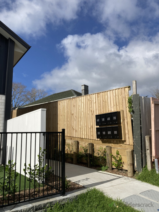 Timber fence on a retaining wall with a beautiful white capped fence and aluminium pool fence.