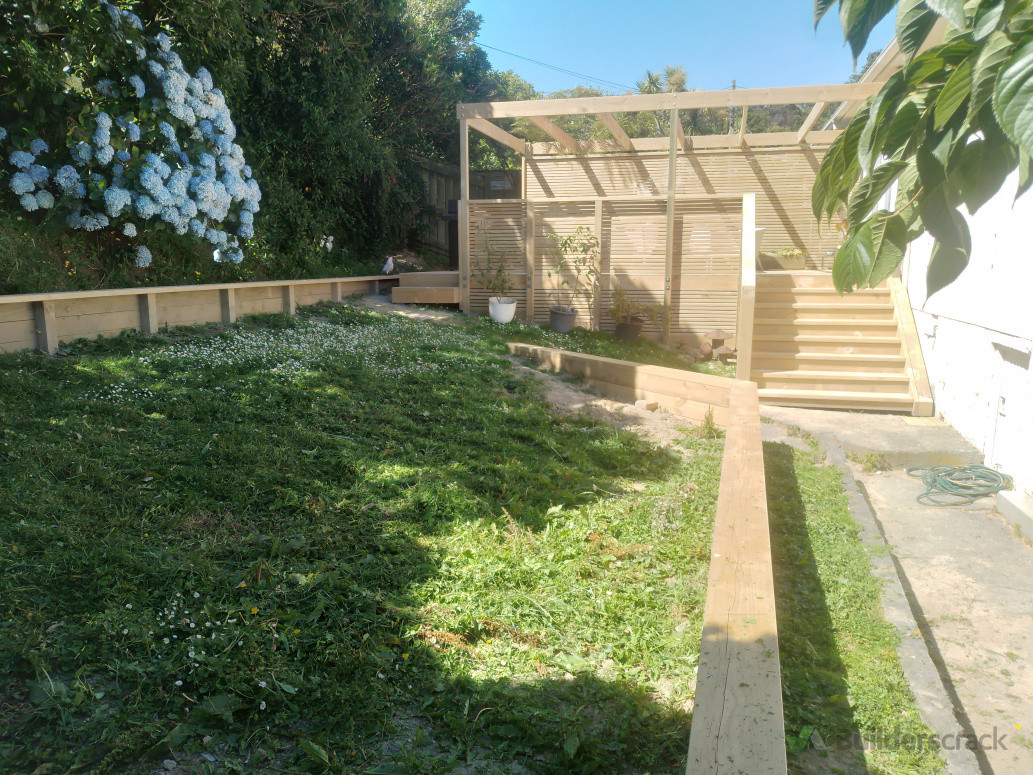 New retaining to support creation of flat lawn area, w/ view of new deck