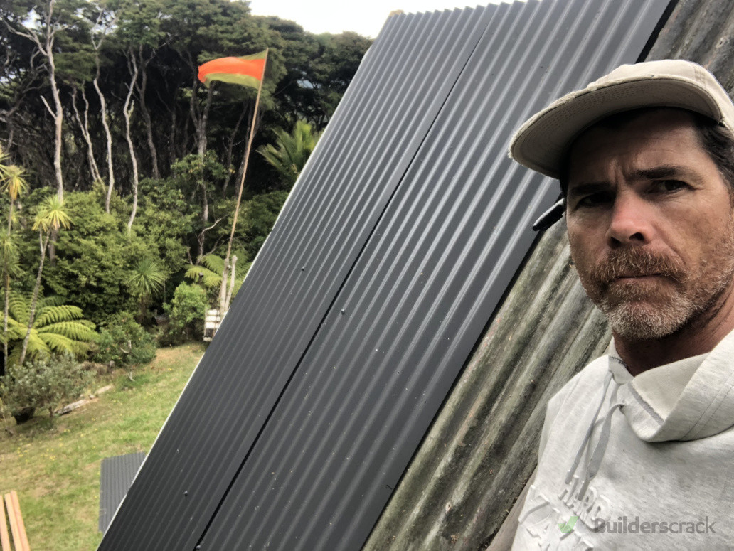 Replacing sheets of roofing on an A frame house. Great Barrier Island.