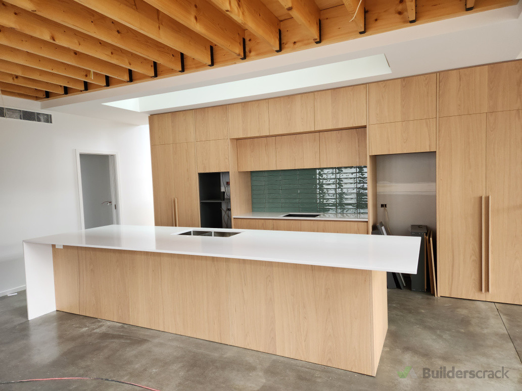 Exposed floor joists and kitchen. Architectural new build.