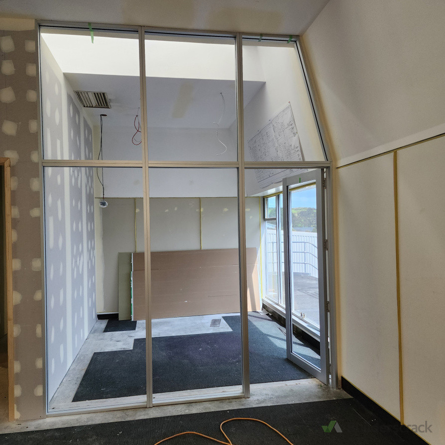 Installation of new 90 mm wall framing and custom aluminium wall partitioning with integrated glass panels.