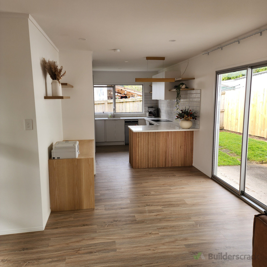 Complete kitchen renovation carried out, including installation of a new kitchen with custom wood-grain end panels and new appliances. The custom detailing provides a standout designer finish. New flooring installed throughout the kitchen and living area.