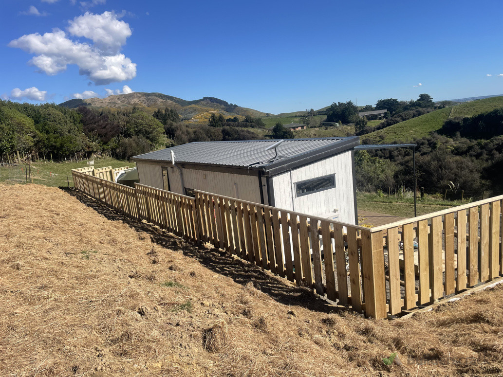 AJ's completed fence along the top of a retaining wall
