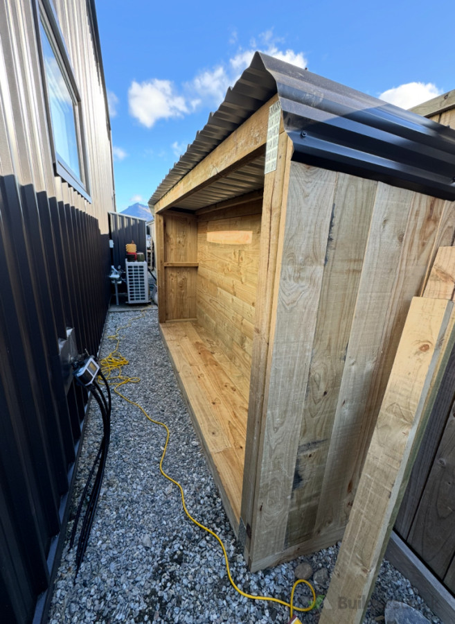 Large firewood storage area with corrugated iron roof
