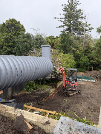 Slow and steady drag down the tight gap of the house balancing on top of the retaining wall.